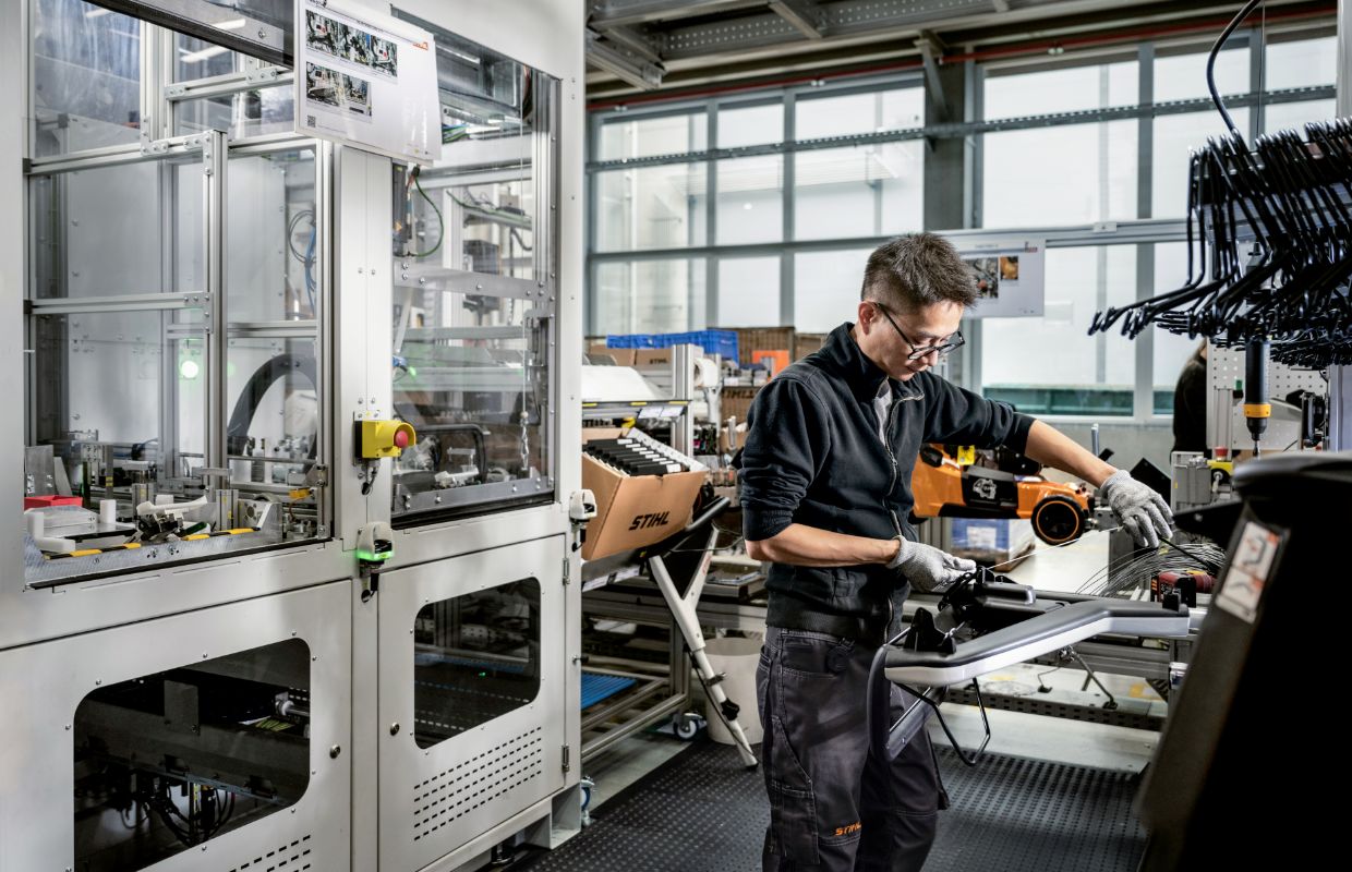 A man stands at an assembly line and works.