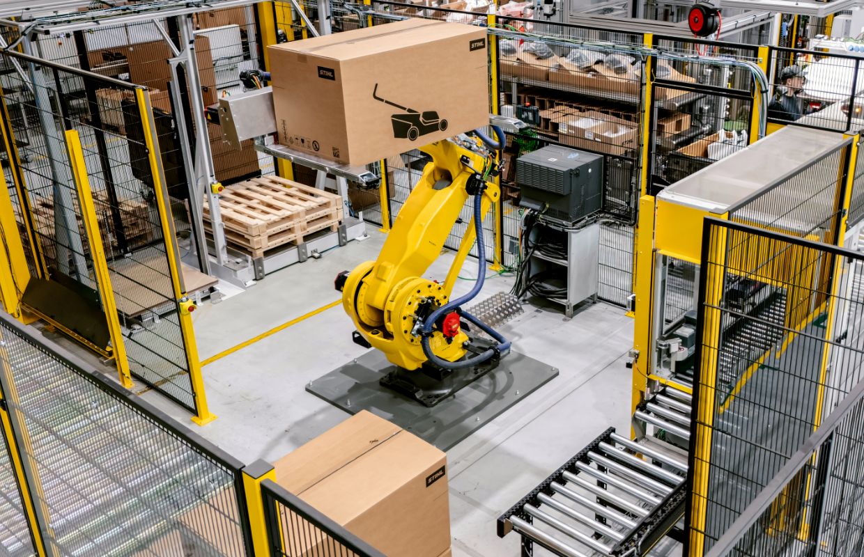 View from above of a packing station with lawn mowers. In the centre is a robot.