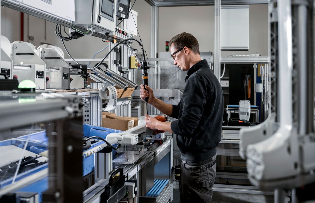 A man stands at an assembly line and works.