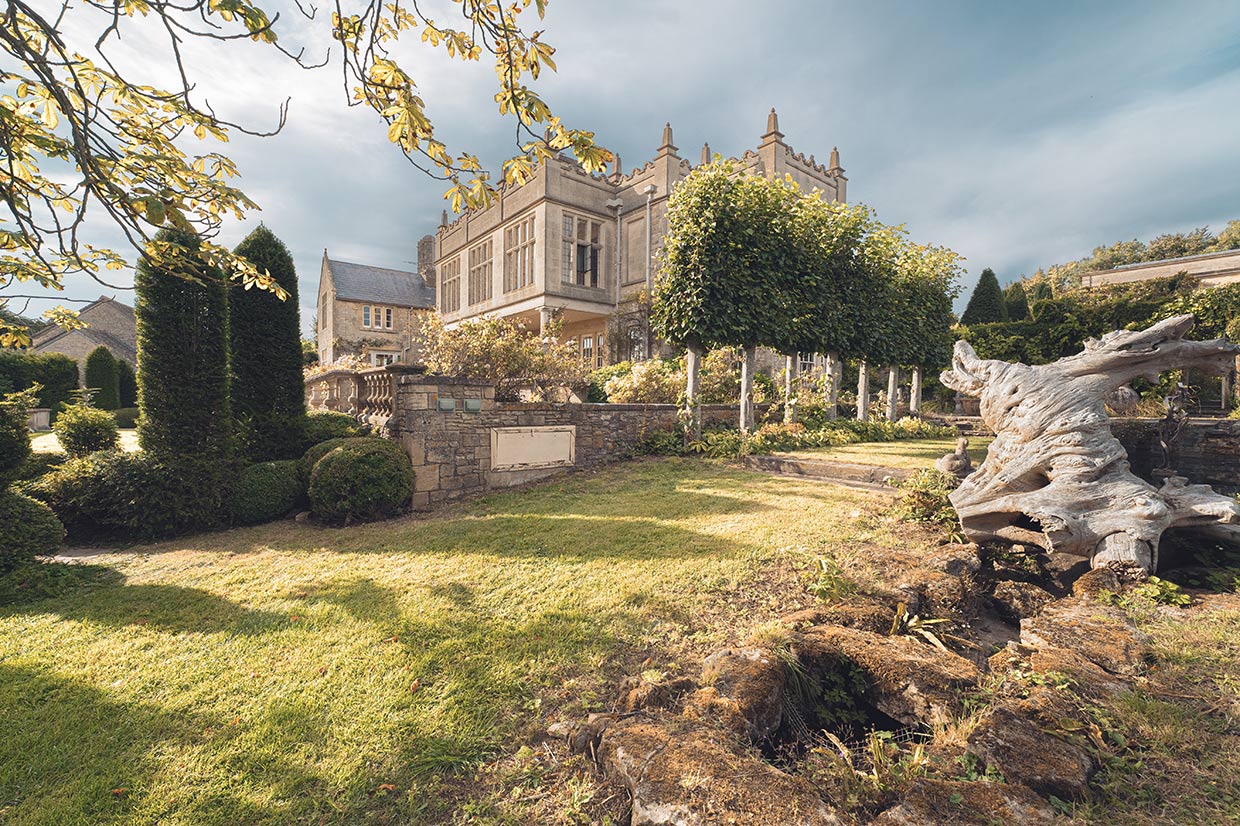 View of the lime tree trellis and the manor house from afar.